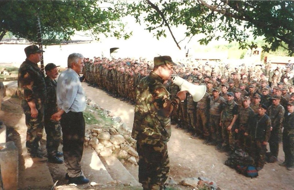 Kolonel Maliq Doçi duke iu folur ushtarëve në Helshan, derisa në krah tij është Xheladin Gashi-Plaku.
